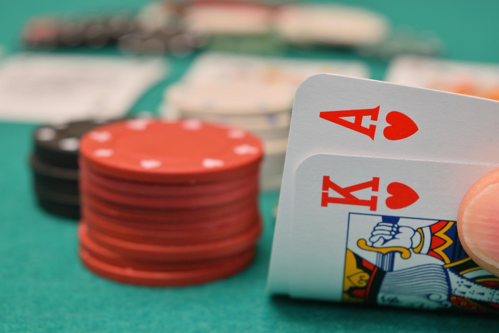 Close-up of gambling chip and cards on table with cards being on focus